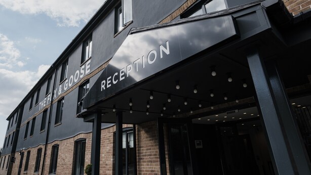 A building with a reception area and a sign that reads "The Fix & Goose." - The Fox & Goose Hotel (London)