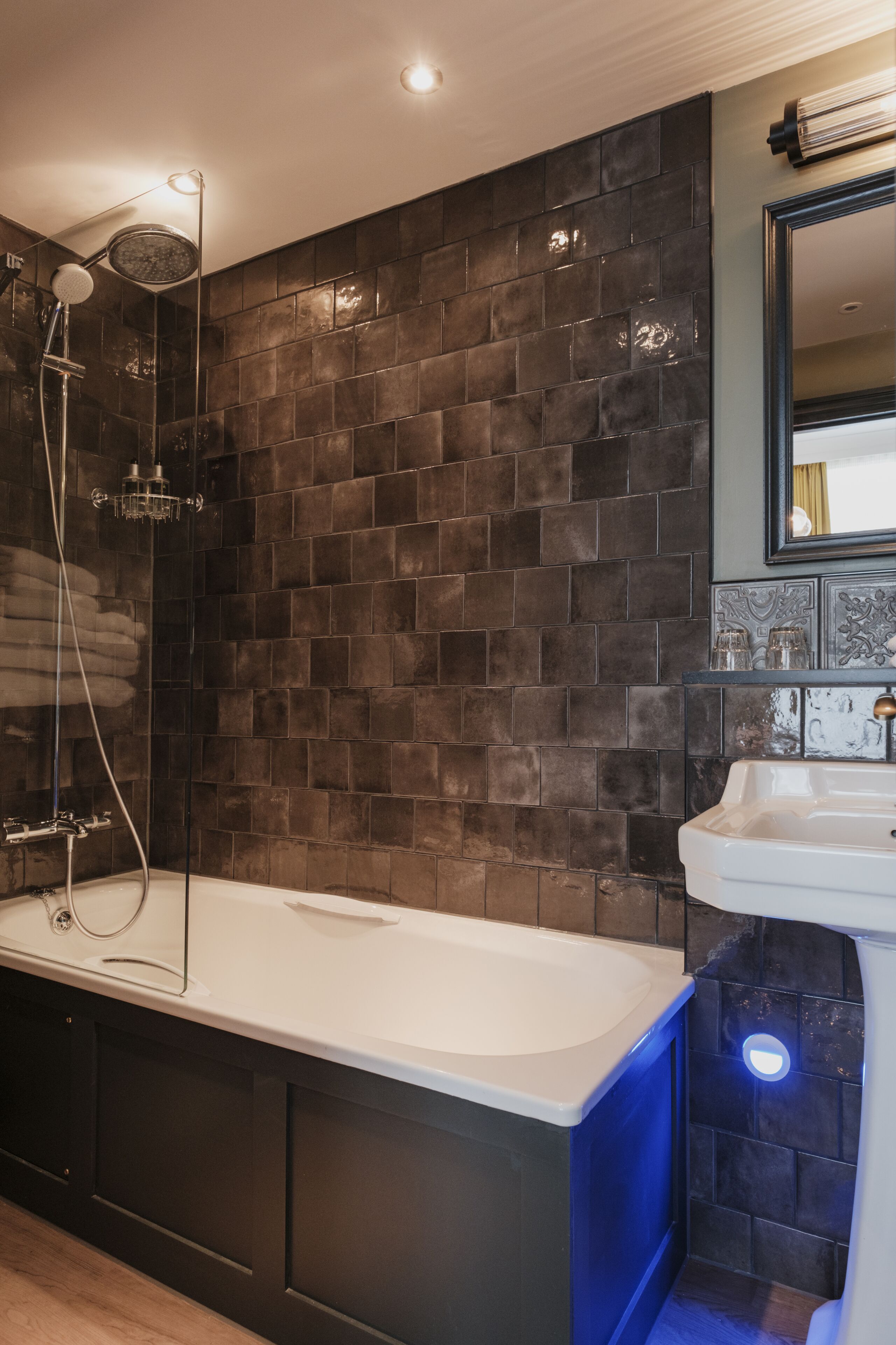 A modern bathroom with a bathtub, a shower, and a sink.