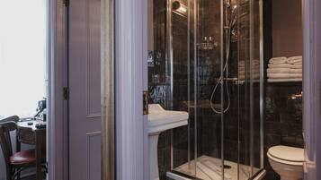 Une salle de bain moderne avec une douche à parois de verre, un lavabo blanc et des toilettes.