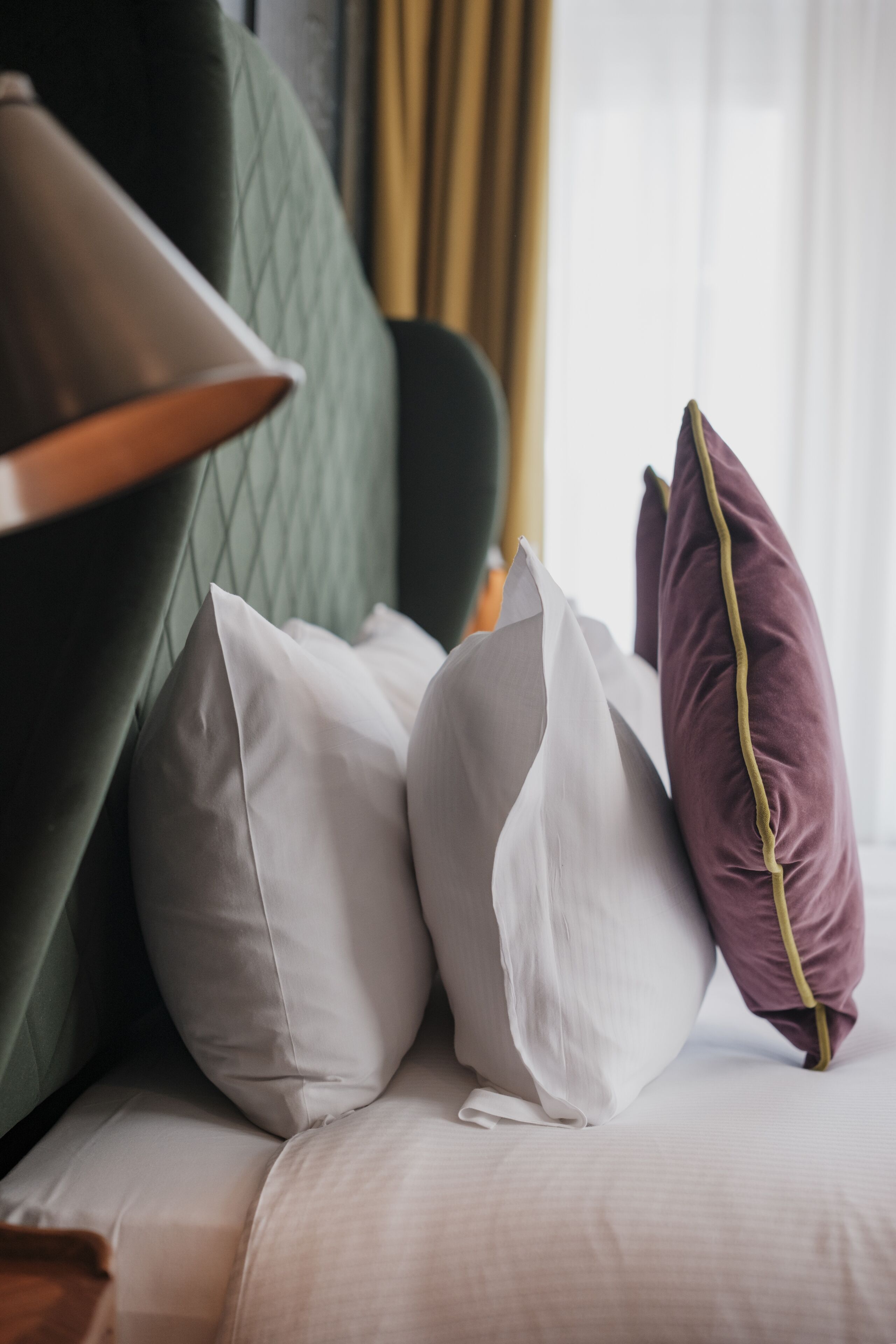 A bed with pillows and a lamp.