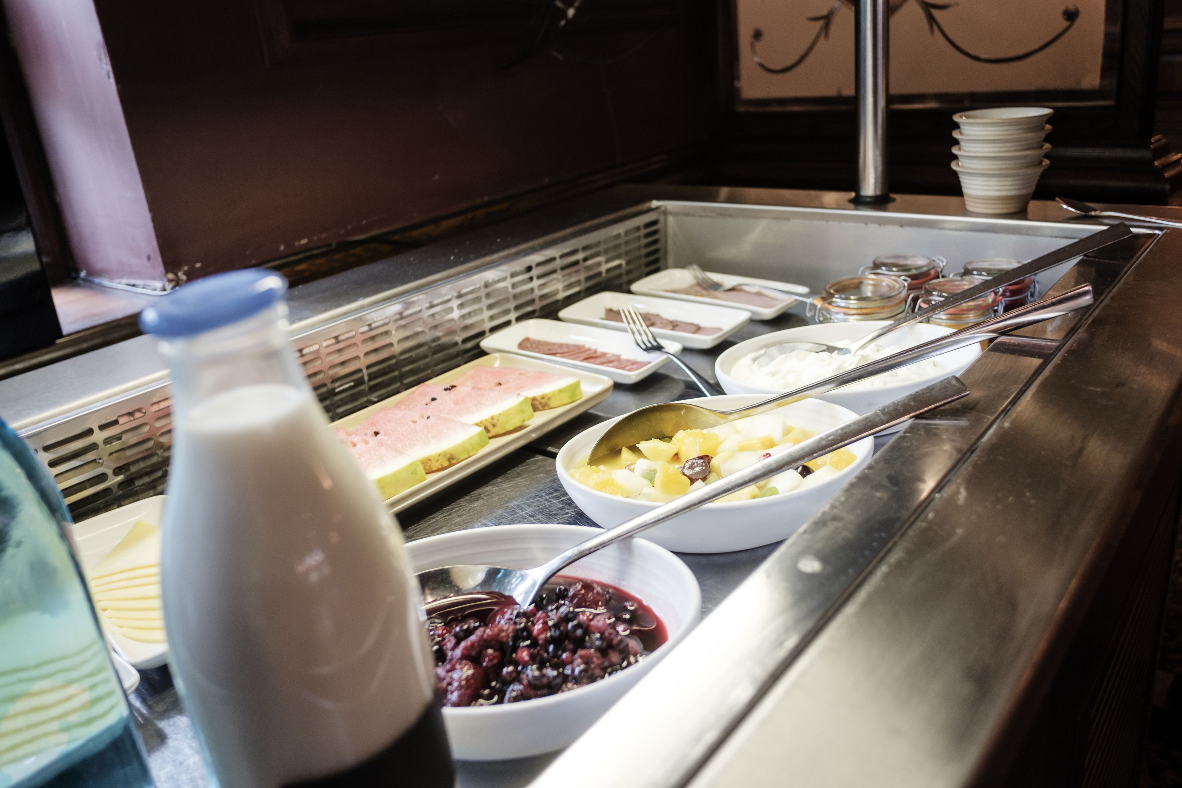 Um buffet com diversos alimentos e utensílios.