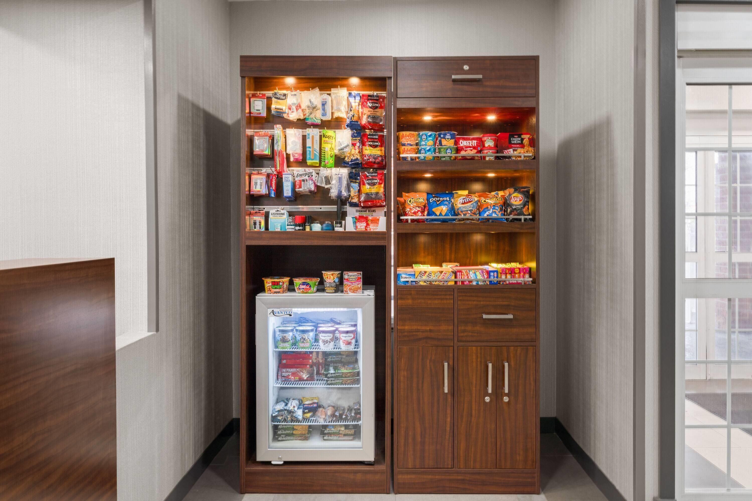 A vending machine and a snack shelf in a hallway.