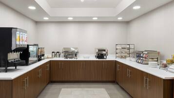 A modern kitchen with built-in appliances, wooden cabinets, and a central island.