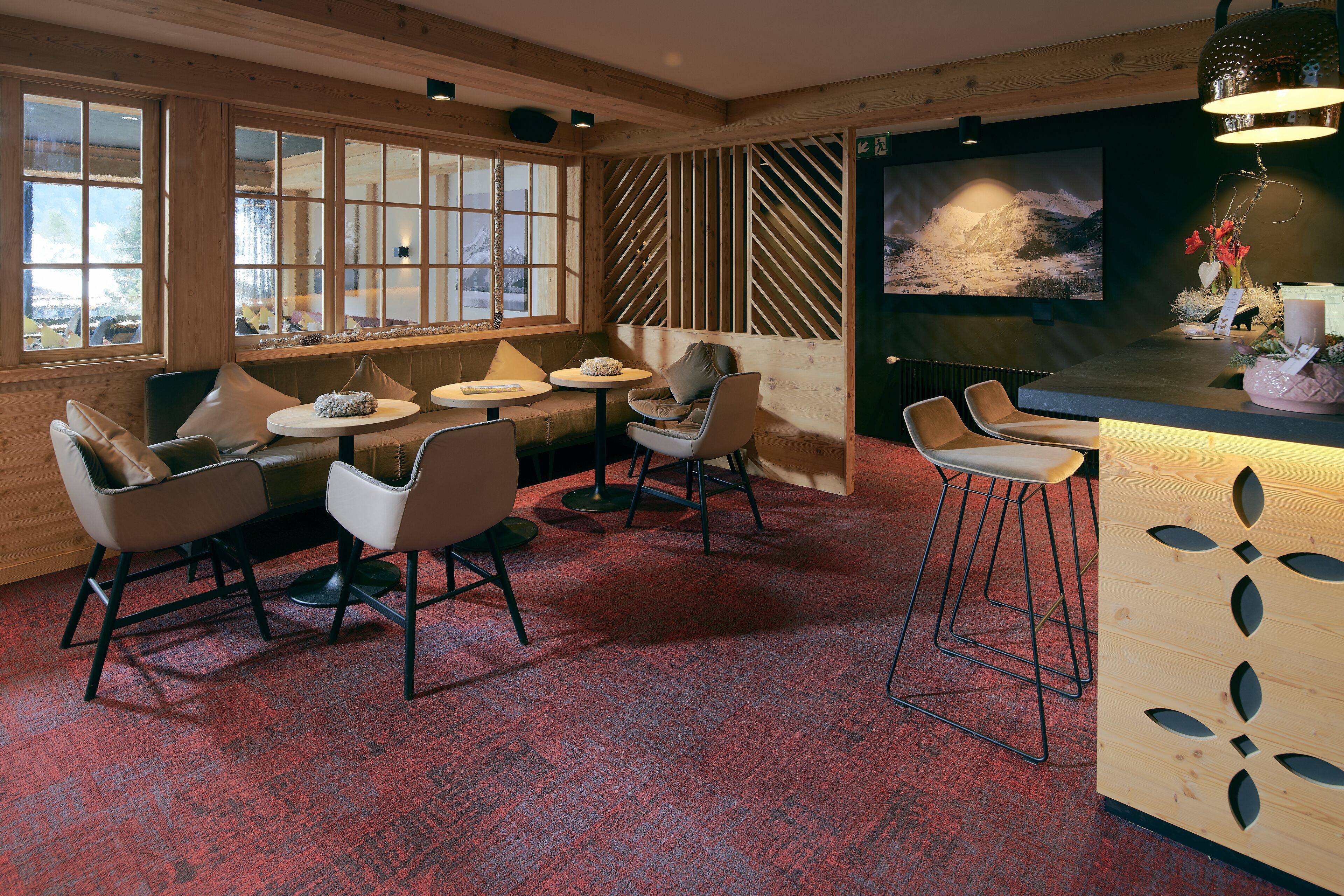 A cozy room with wooden walls, a large window, and a bar area.