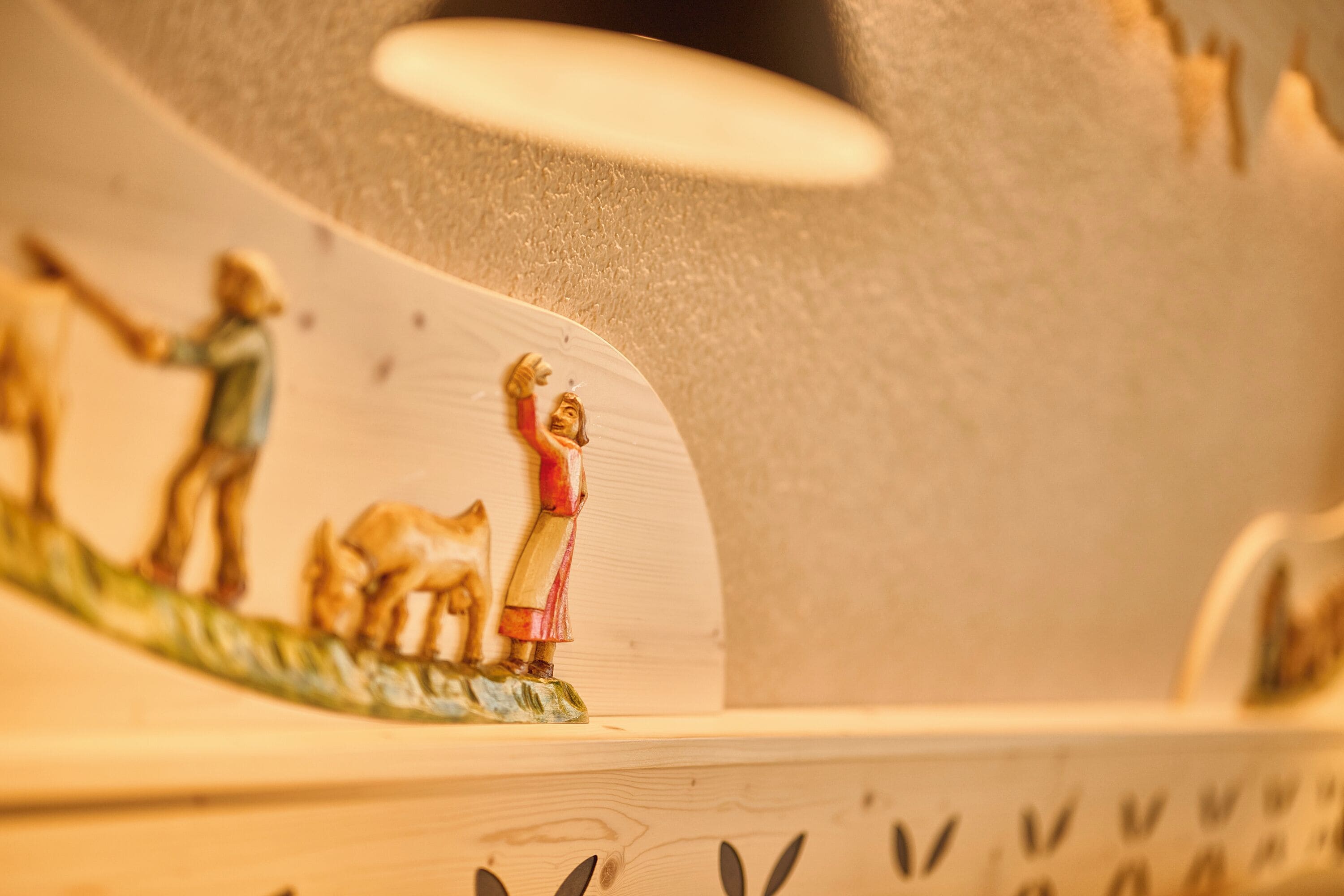 A wooden sculpture with figures of people and animals.