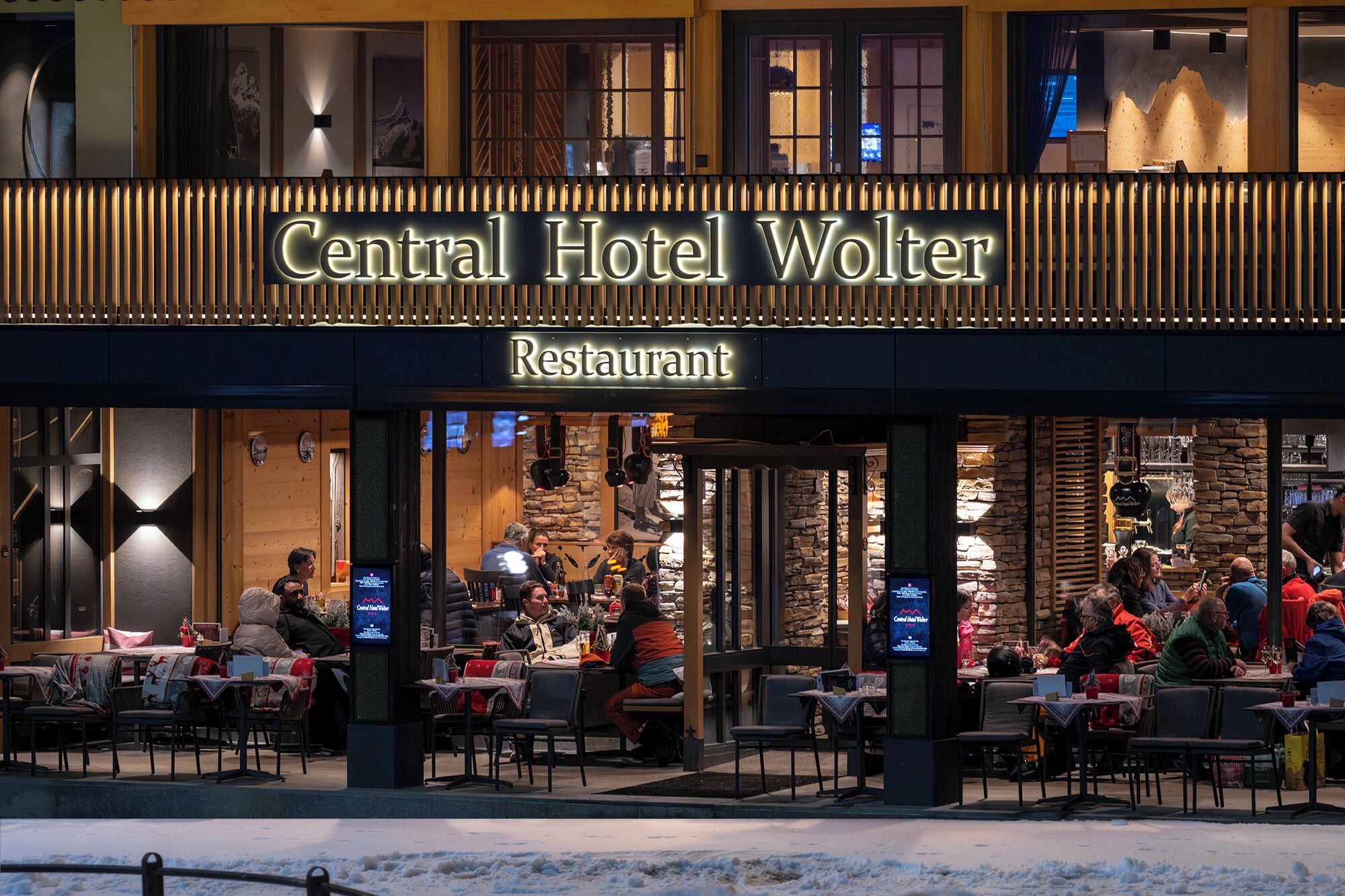The exterior of Central Hotel Wolter Restaurant with outdoor seating and stone walls.
