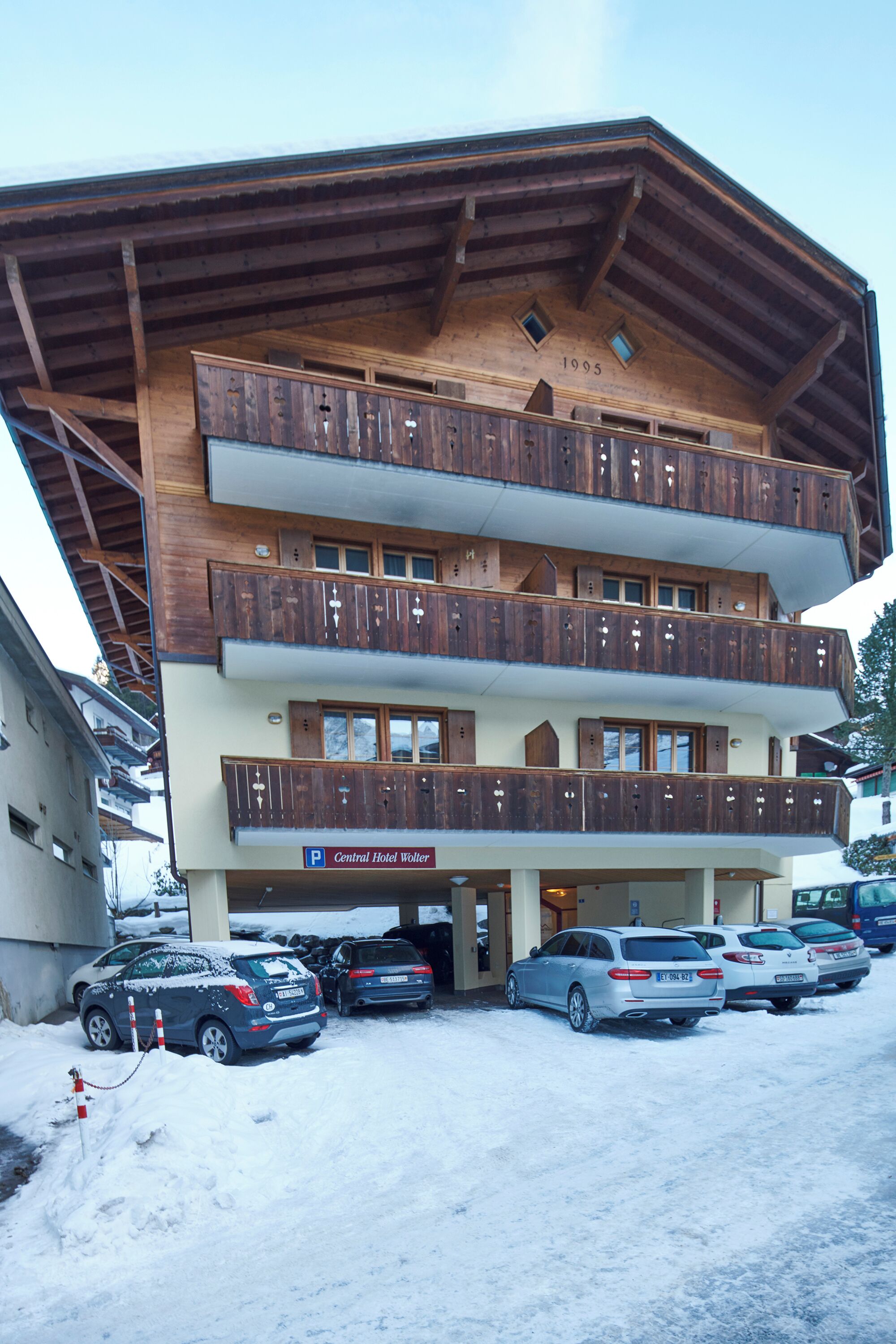 A multi-story hotel with wooden balconies and a sign indicating it is the Central Hotel Woller.