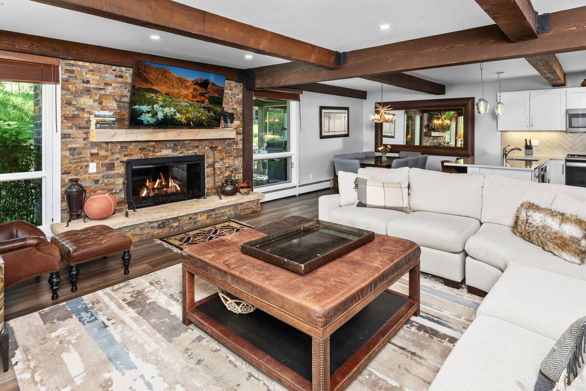 A modern living room with a fireplace, a white sofa, and a coffee table.