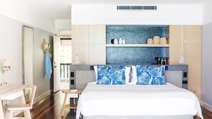A modern bedroom with a large bed, wooden furniture, and a tiled backsplash.