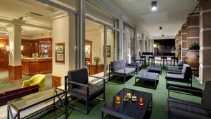 Un vestíbulo de hotel con zona de bar, asientos y vista al bar.