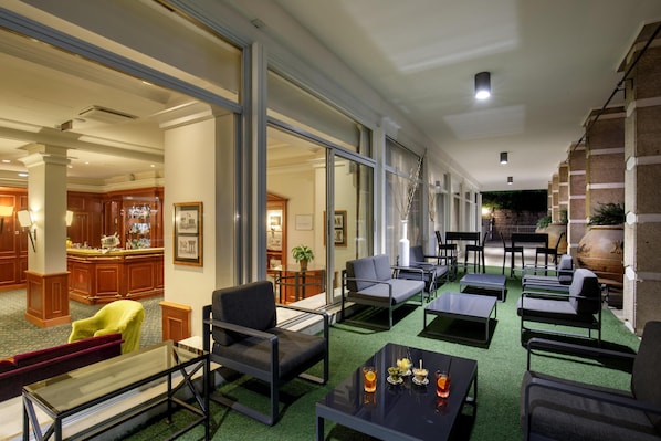 Un hall d’hôtel comprenant un bar, des espaces pour s’asseoir et une vue sur le bar.