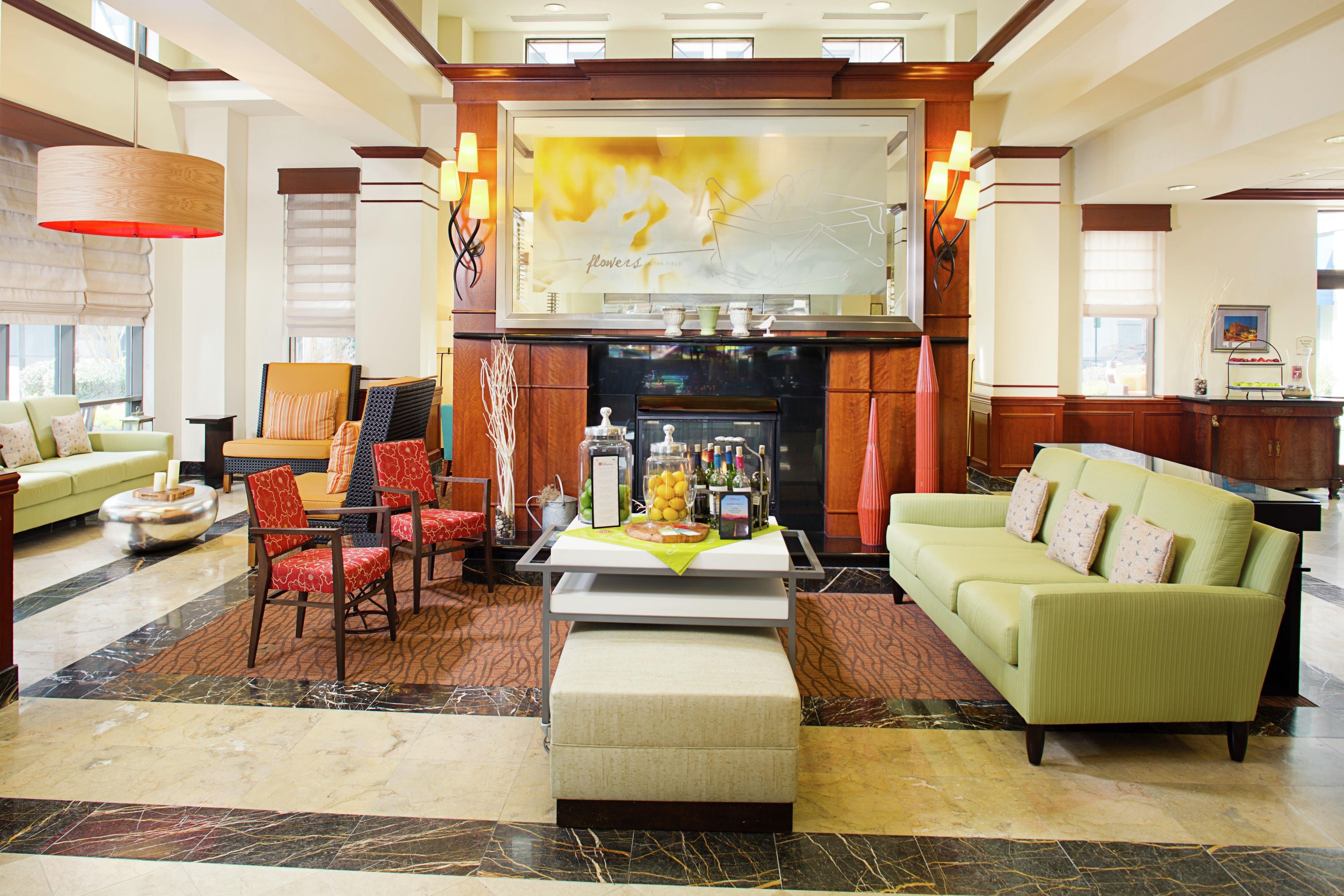 A spacious lobby with a fireplace, seating area, and a large window.