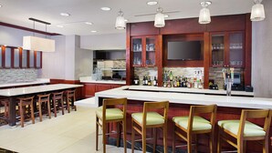 Een moderne keuken met een bar, houten stoelen en een groot eiland.