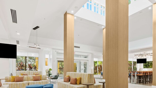 Un vestíbulo espacioso con techos altos, ventanas amplias y un diseño moderno.