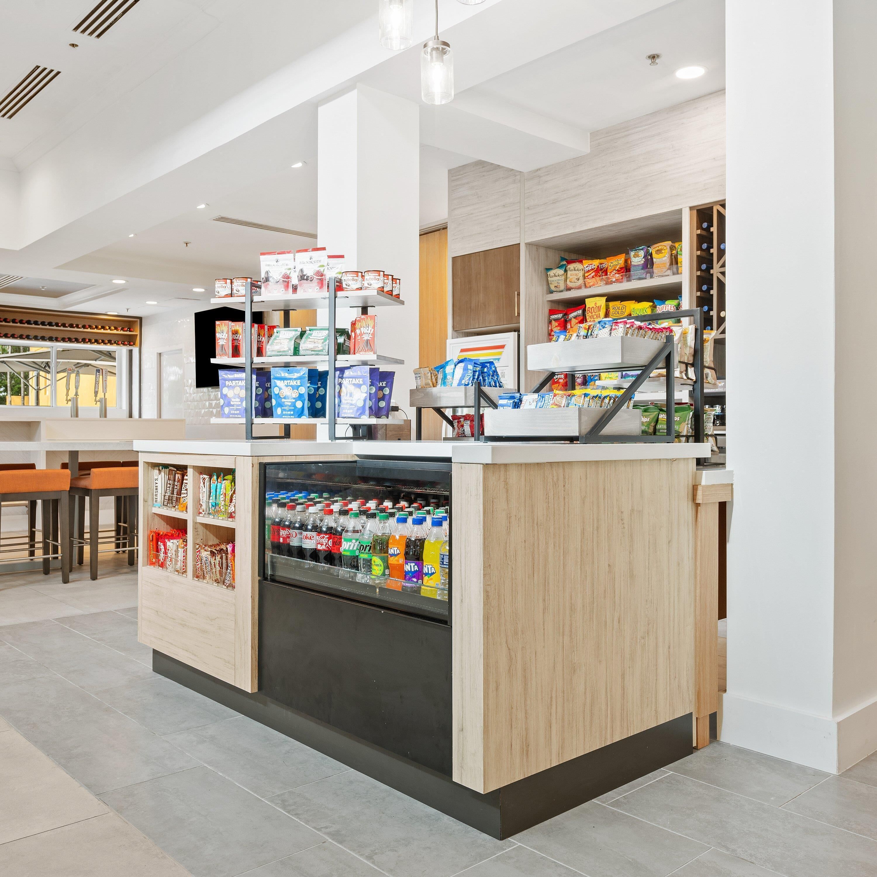 Um quiosque moderno e automatizado, com bebidas geladas, snacks e produtos embalados.