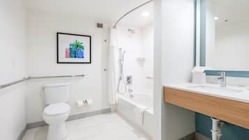 A modern bathroom with a toilet, shower, and sink.