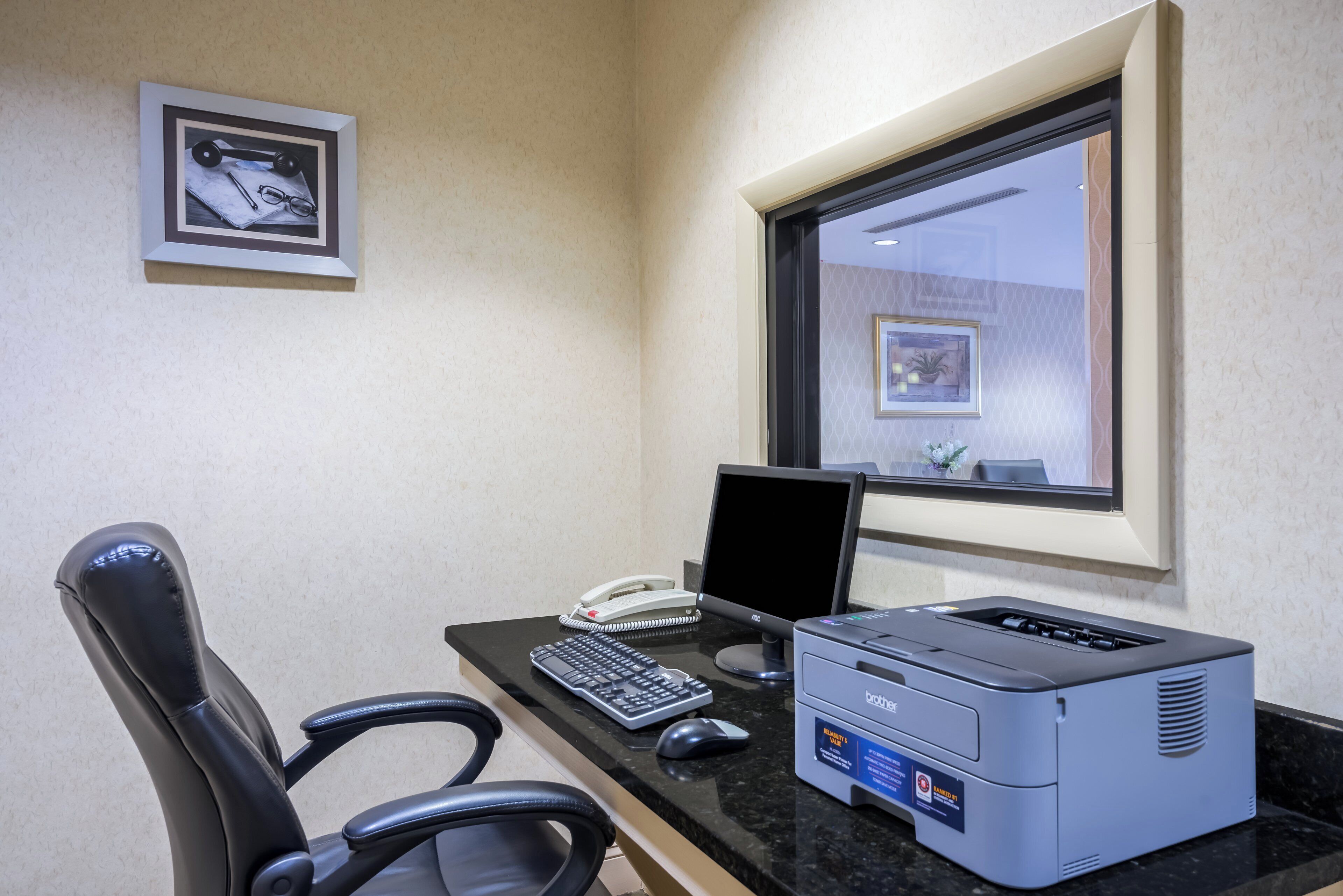 A modern office space with a desk, computer, printer, and office chair.