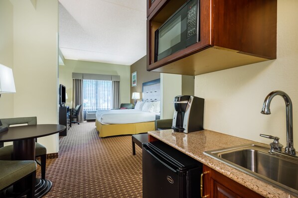 A hotel room with a bed, a desk, a chair, a microwave, a coffee maker, and a sink. - Holiday Inn Express North East by IHG (North East)