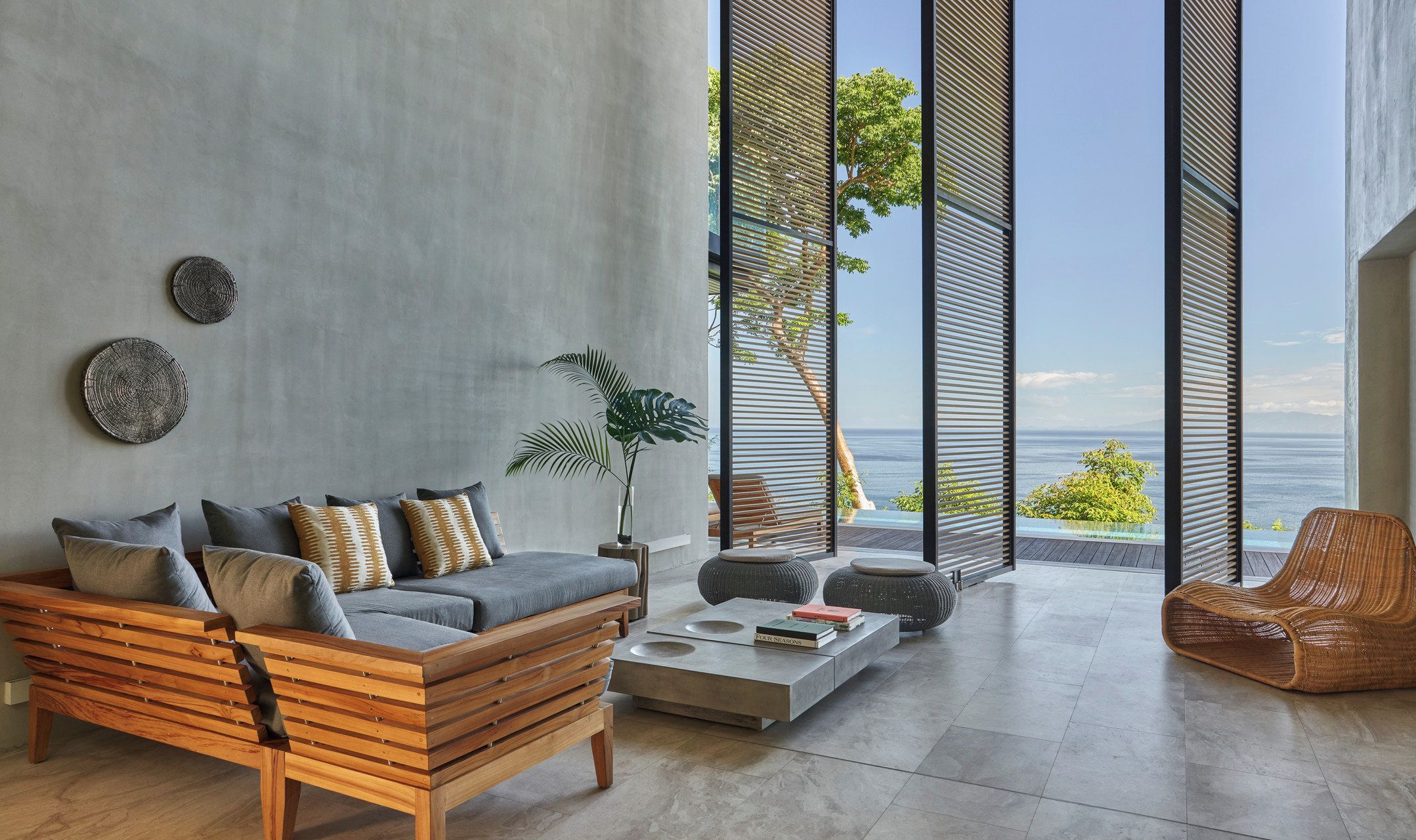 Ein modernes Wohnzimmer mit Sofa, Couchtisch und Blick auf den Ozean.