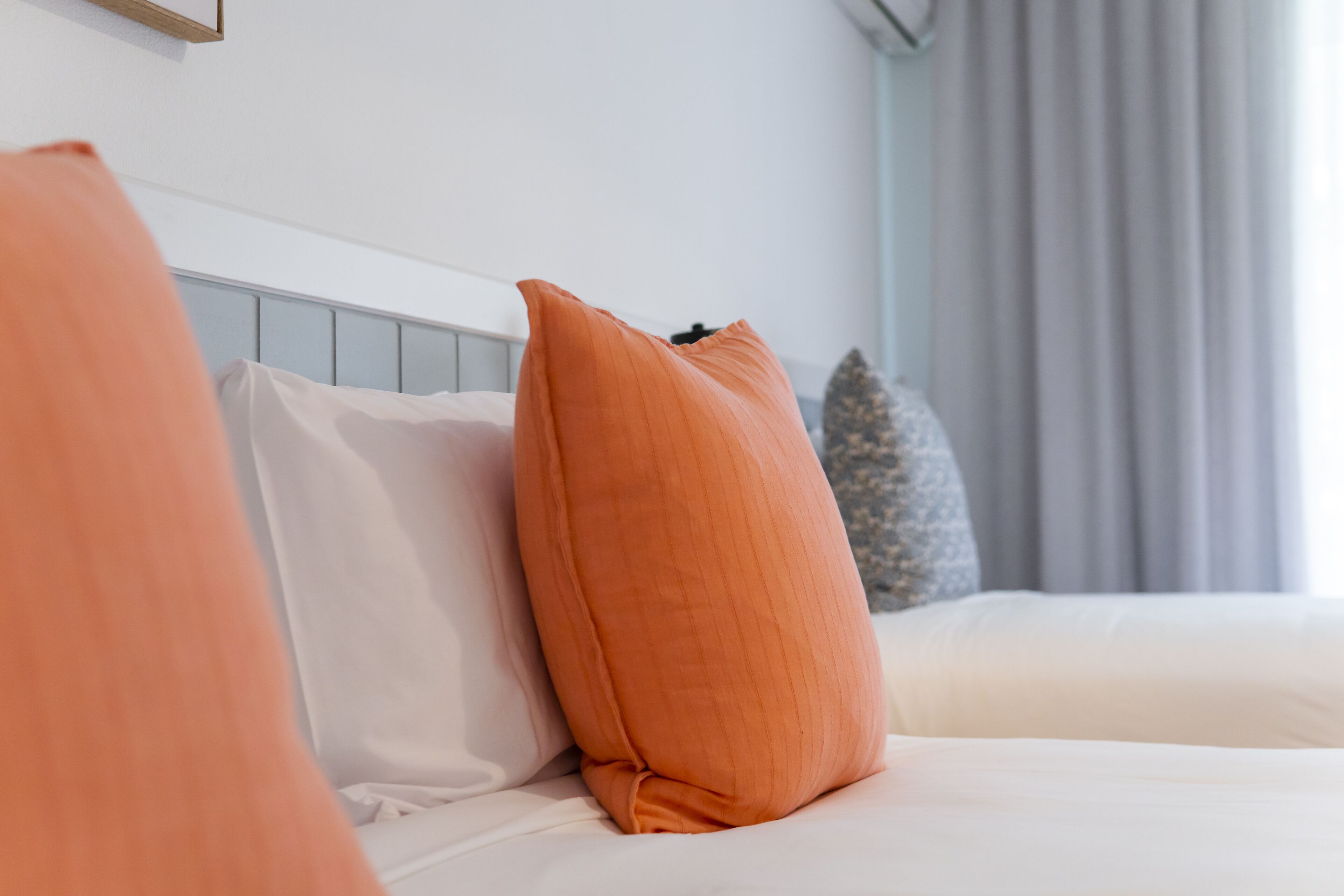 Una cama con ropa de cama blanca y un cabecero de madera.