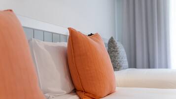 Una cama con ropa de cama blanca y un cabecero de madera.