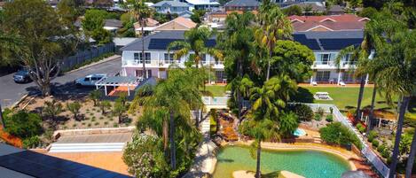 A residential area with a swimming pool, solar panels, and a variety of houses.
