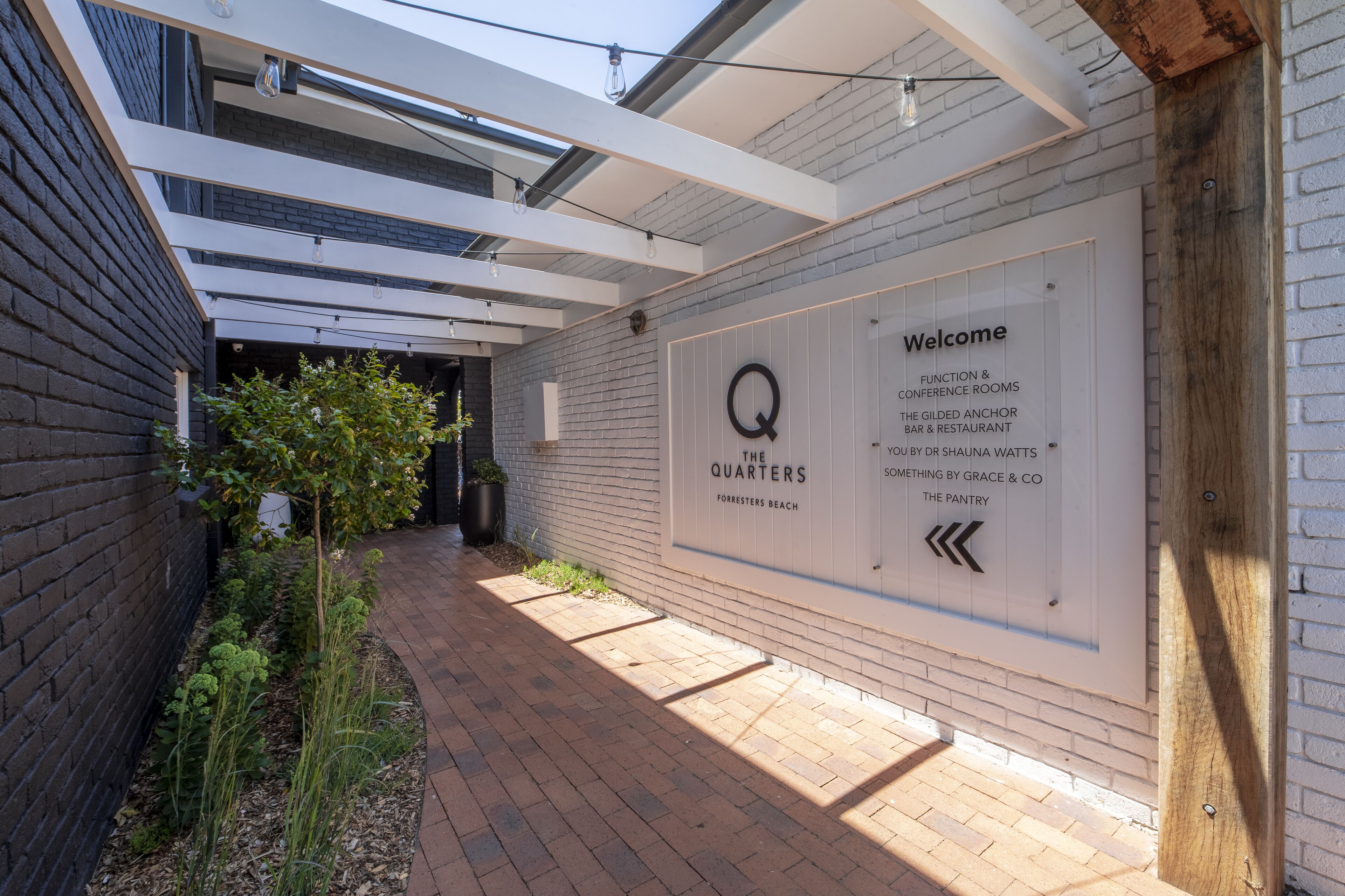 A corridor with a sign indicating 'The Quarters' and a welcome message.