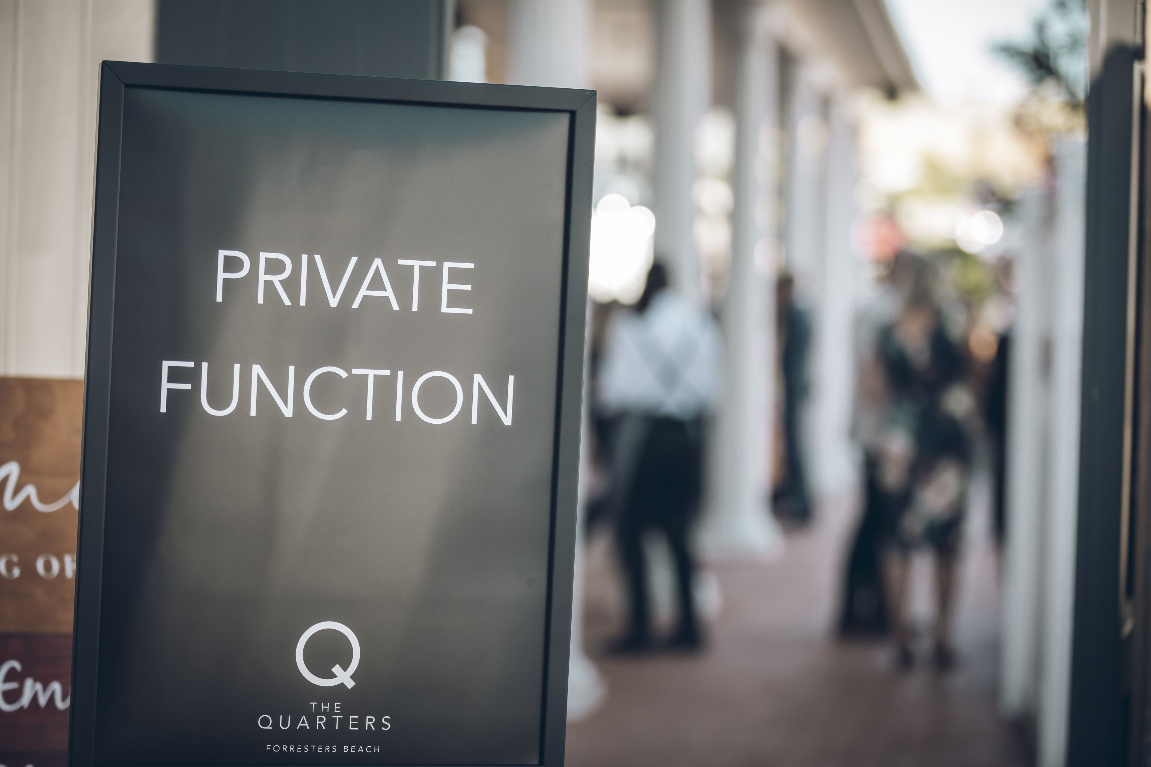 Um letreiro com o texto 'PRIVATE FUNCTION' e 'THE QUARTERS FORRESTERS BEACH'.