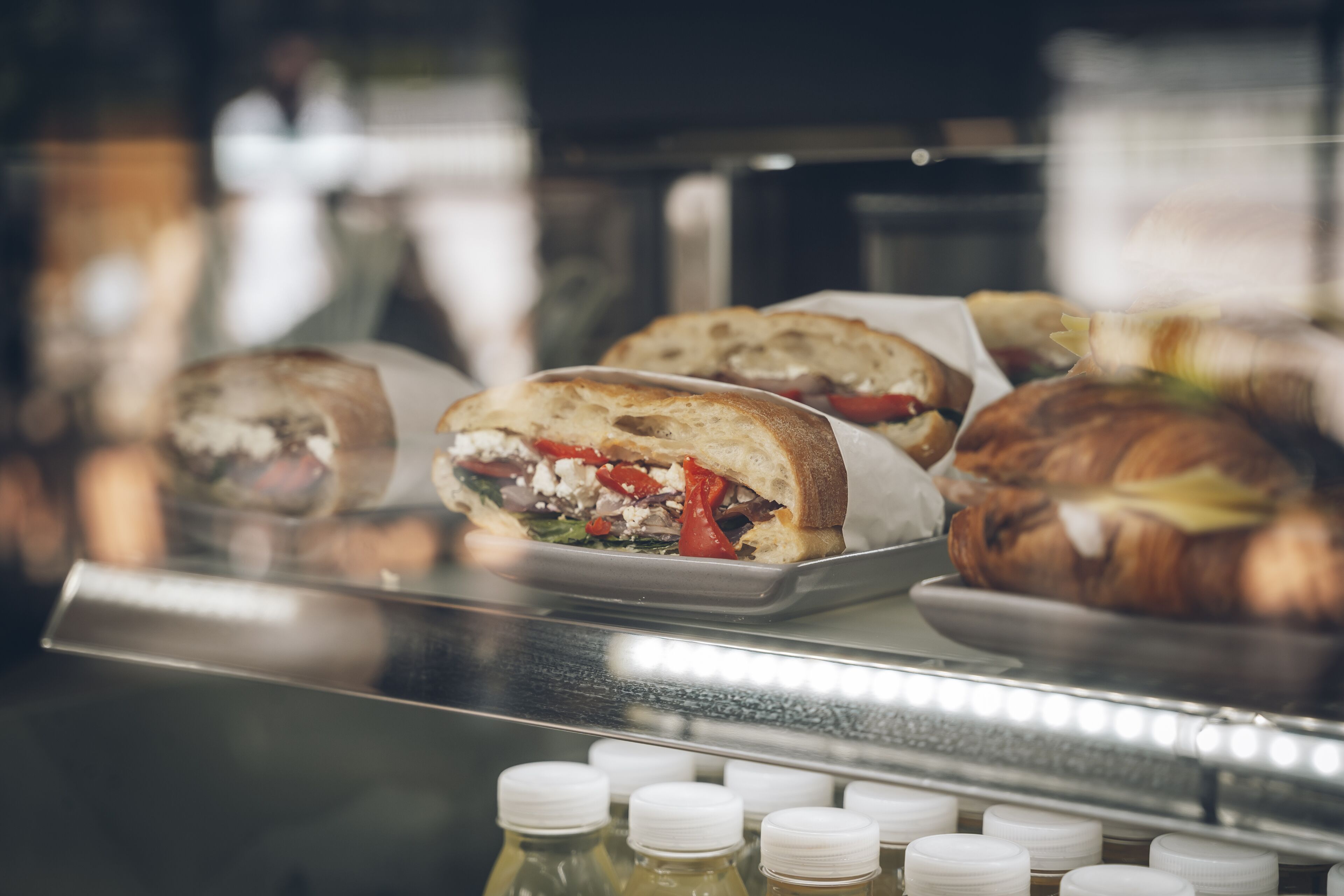 Une présentation de sandwichs et de pâtisseries dans une boulangerie.
