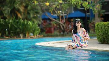 Relax by the serene pool surrounded by lush greenery.