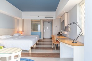 A modern hotel room with a large bed, a desk, and a TV. - Mercure Convention Center Ancol (Jakarta)