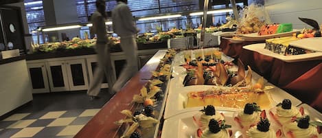 A buffet with various dishes and a person in the background.