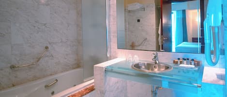 Ein Badezimmer mit Badewanne, Waschbecken, Spiegel und Dusche.