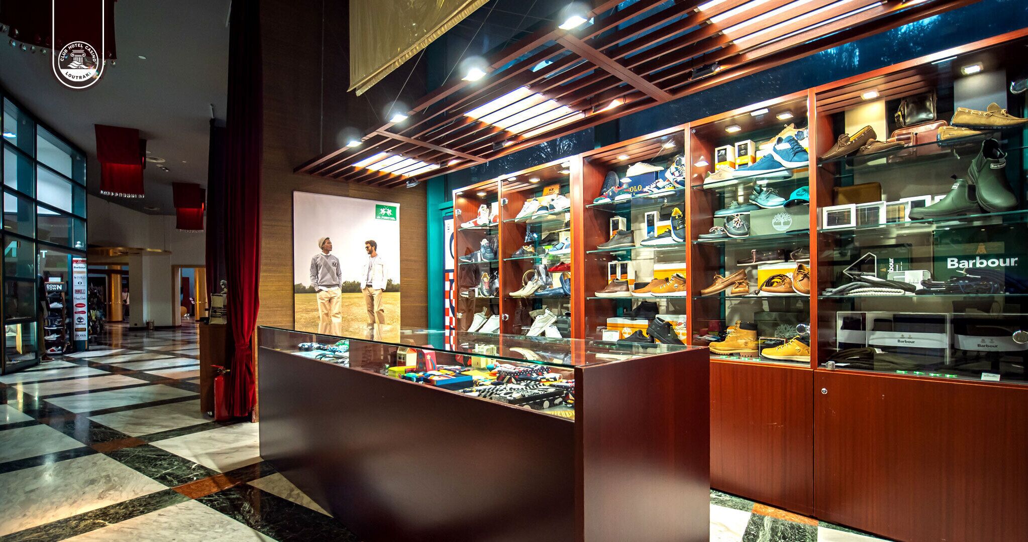 Tienda de zapatos con vitrinas de vidrio y suelo a cuadros.
