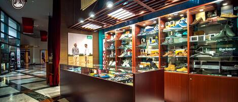 Tienda de zapatos con vitrinas de vidrio y suelo a cuadros.