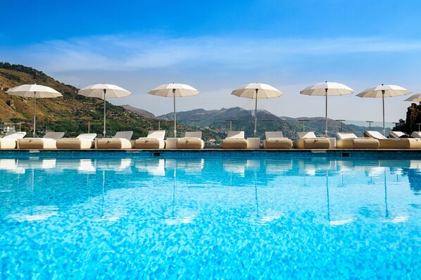 Seasonal outdoor pool, open 9 AM to 7 PM, pool umbrellas, pool loungers