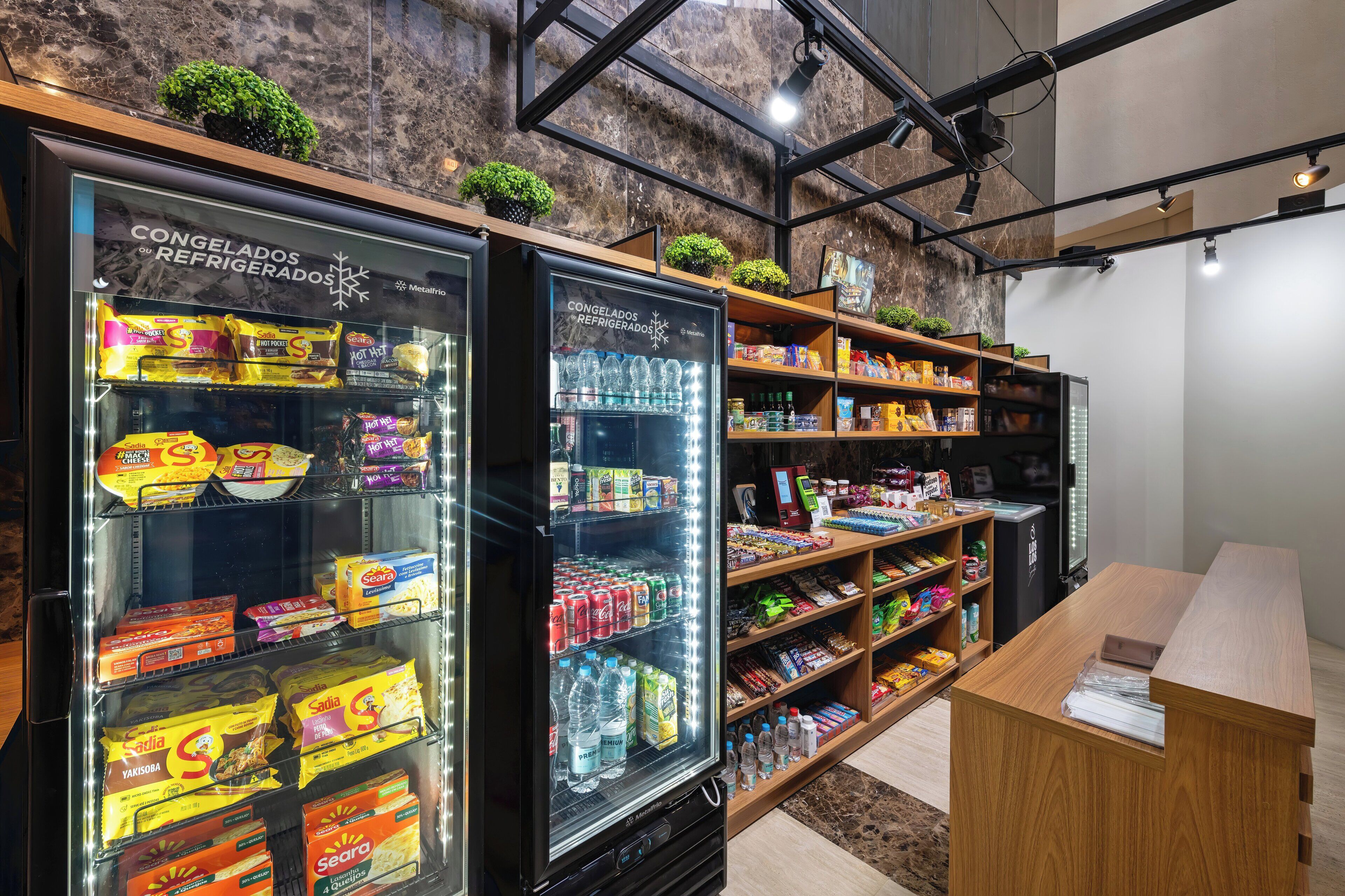 Mostrador refrigerado con diversos alimentos y bebidas envasados.