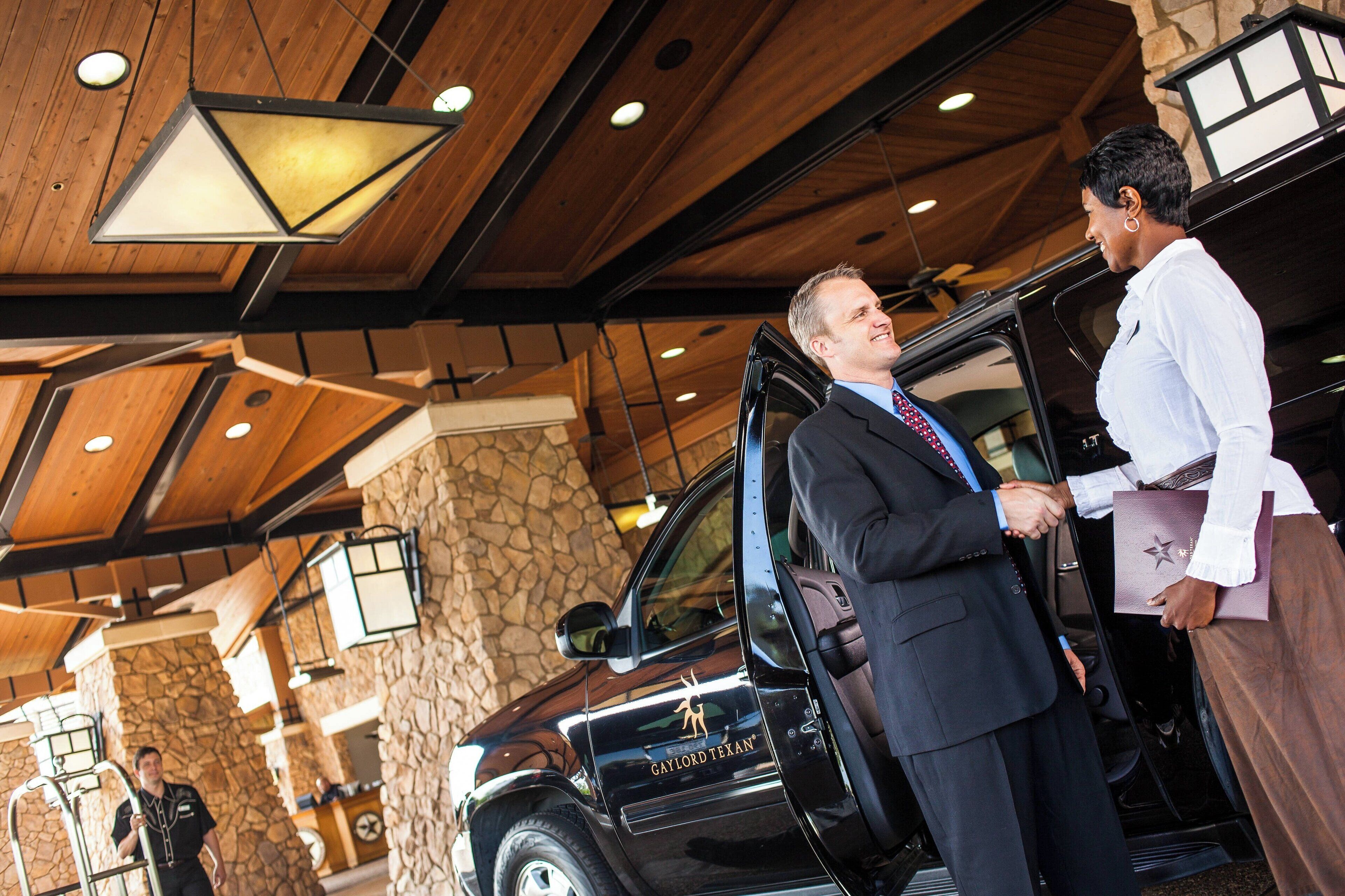 A black SUV with "GAYLORD TEXAN" branding parked inside a building with wooden beams and stone walls.