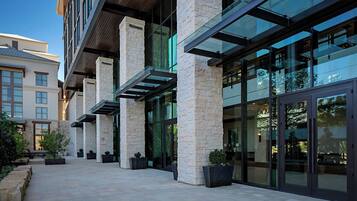 A modern building with large glass windows and stone pillars.
