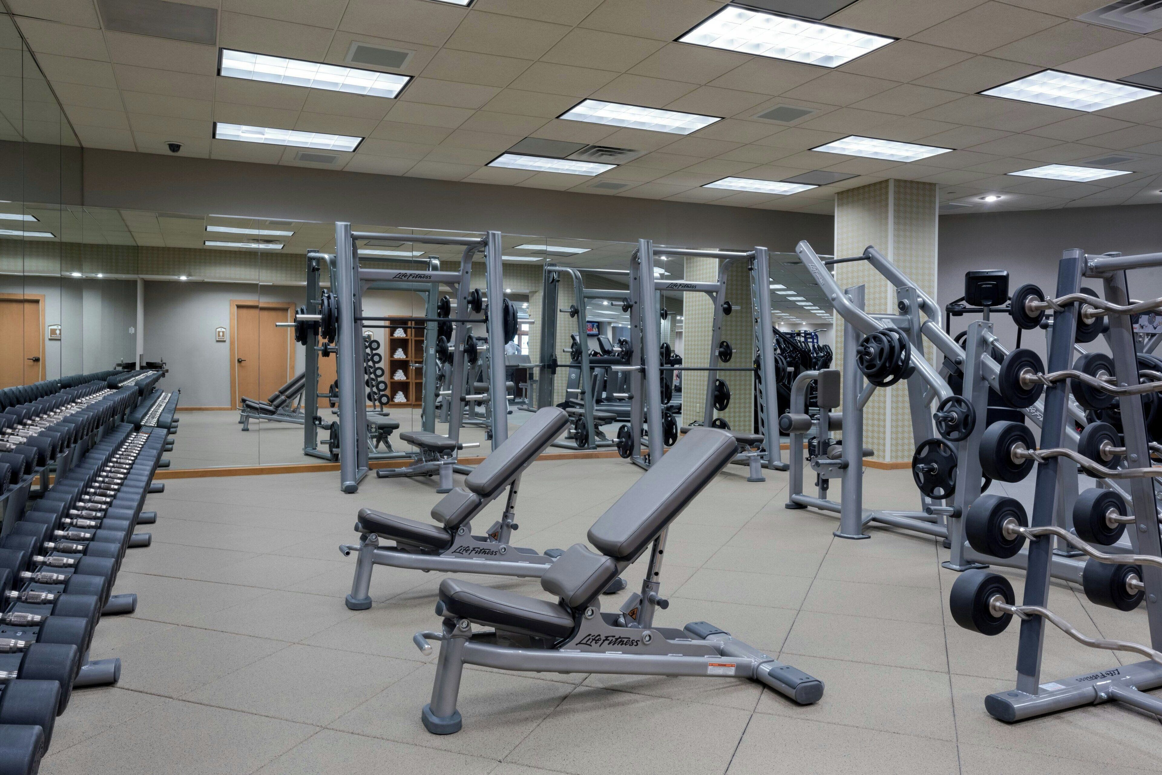 A gym with weightlifting equipment, treadmills, and cardio machines.