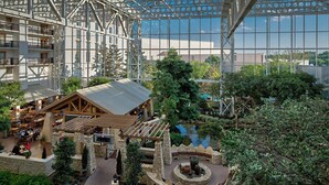 Un atrium à plusieurs niveaux, doté d’une cour centrale, de murs en pierre et d’une pergola en bois.