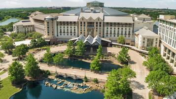 A large hotel with a central courtyard, a bridge, and a lake.