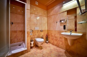 Un bagno con vasca, water, lavandino e specchio.