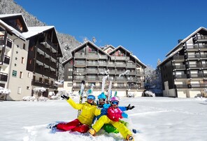 A ski resort with multi-story buildings, ski slopes, and snow-covered trees.