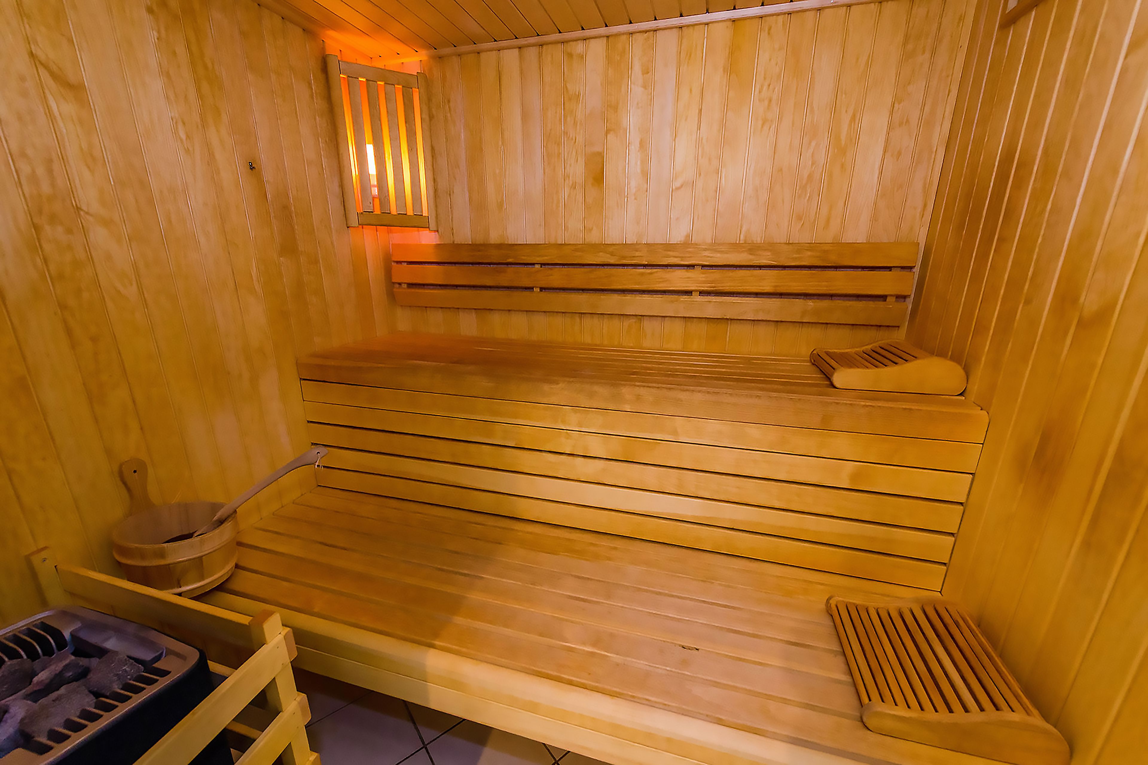 A sauna with wooden benches and a slatted seat.