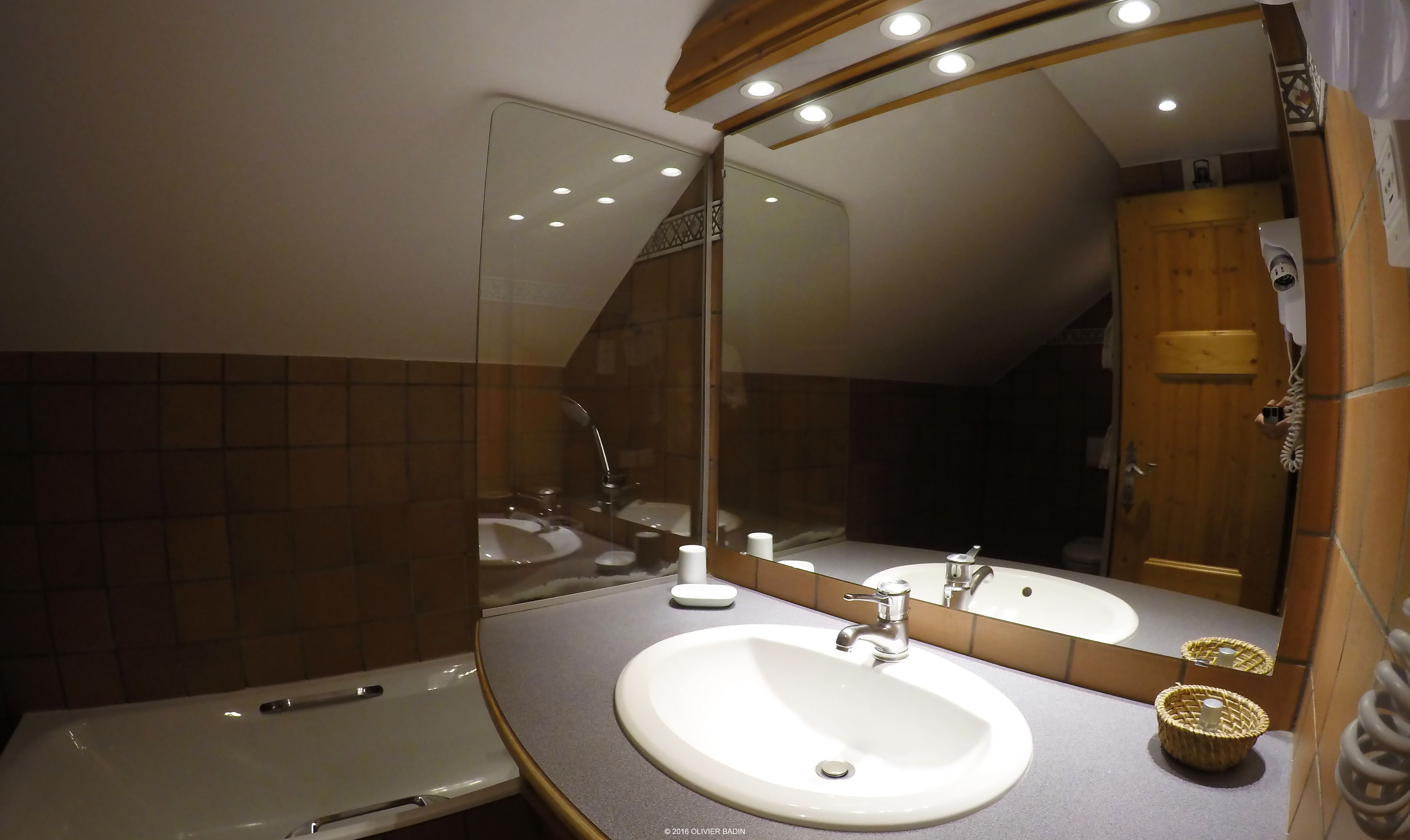 A bathroom with a white sink, a mirror, and a bathtub.
