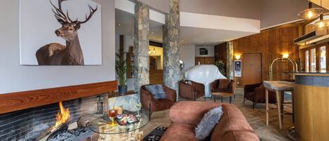 A modern living room with a fireplace, a large deer painting, and a cozy seating area.