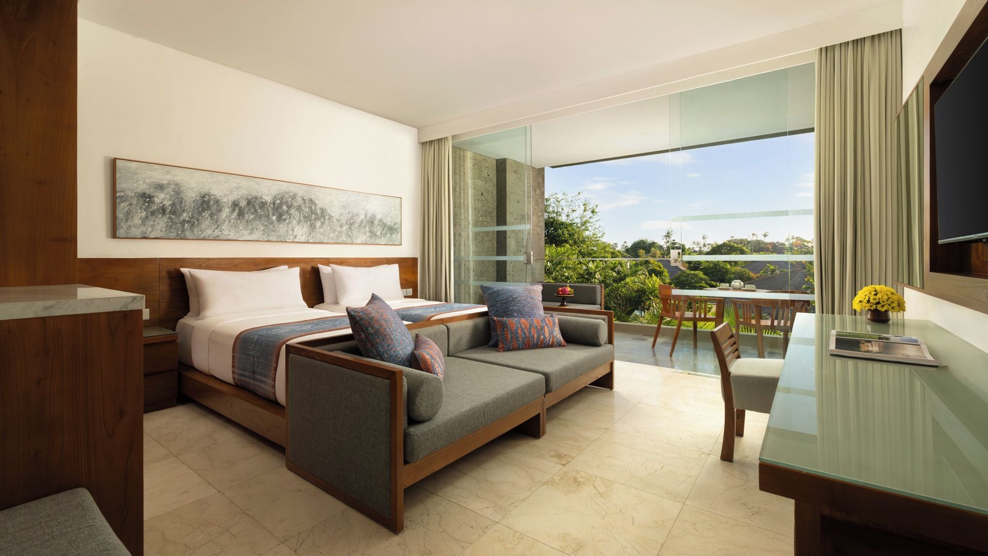 Ein modernes Hotelzimmer mit Bett, Sofa und Essbereich mit Blick.