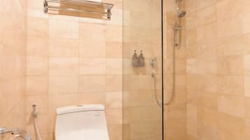 A bathroom with a toilet, a glass-enclosed shower, and a towel rack.
