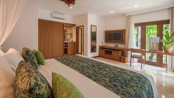 A bedroom with a large bed, a desk, a chair, and a television.